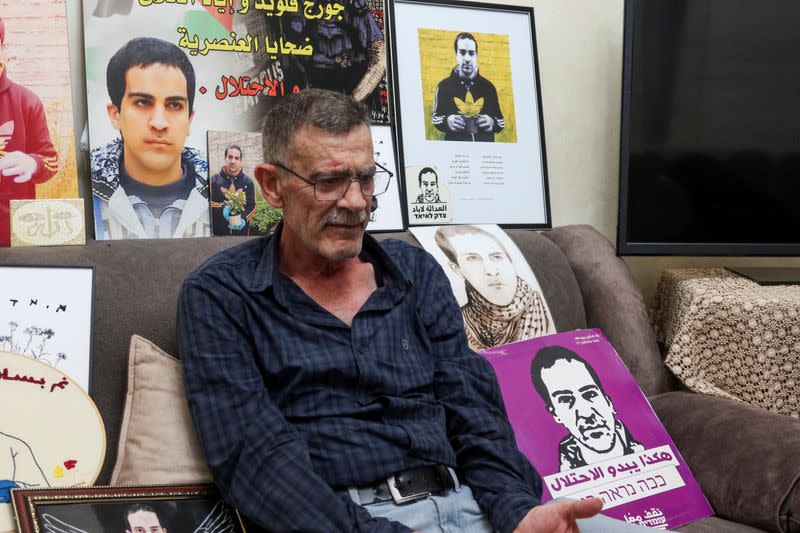 Kheiry al-Halaq, the father of Iyad al-Halaq, an unarmed autistic Palestinian man who was shot dead by Israeli police, sits surrounded by pictures of his son in his family home in East Jerusalem