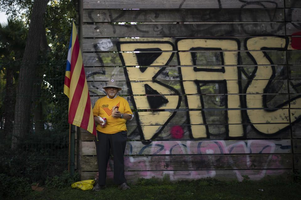 A Catalan pro-independence protester pauses to eat a sandwich during a demonstration in Barcelona, Spain, Saturday, Oct. 26, 2019. Protests turned violent last week after Spain's Supreme Court convicted 12 separatist leaders of illegally promoting the wealthy Catalonia region's independence and sentenced nine of them to prison. (AP Photo/Felipe Dana)