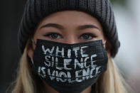 06.0Ellie MacInnes trägt einen selbstgestalteten Mundschutz mit der Aufschrift "White Silence Is Violence" während eines Protests vor der US-Botschaft gegen Rassismus und Polizeigewalt. Foto: Brian Lawless / PA Wire / dpa