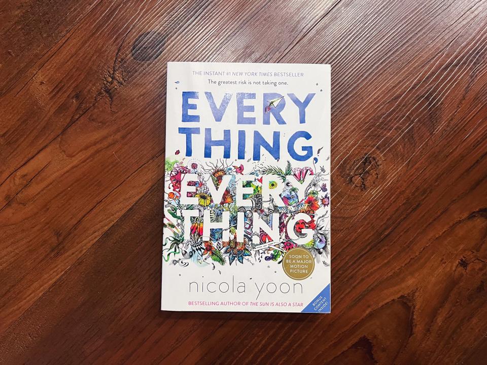 The photo shows the book 'Everything, Everything' by Nicola Yoon on a wooden surface