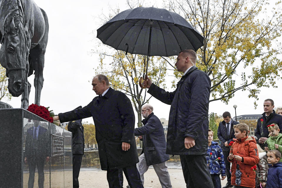 Russian President Vladimir Putin, left, lays flowers at the monument to the soldiers of the Russian WWI Expeditionary Force in France on the Seine river in Paris, France, on Sunday, Nov. 11, 2018. Putin is joining other world leaders at centennial commemorations in Paris this weekend to mark the end of World War I. (Alexei Nikolsky, Sputnik, Kremlin Pool Photo via AP)