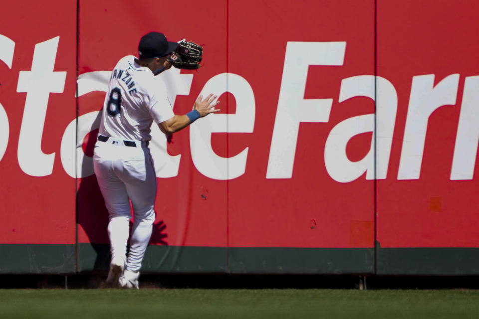 Seattle Mariners left fielder Dominic Canzone collides with the wall after catching a fly ball hit by Chicago Cubs' Mike Tauchman during the second inning of a baseball game Sunday, April 14, 2024, in Seattle. Canzone would leave the game due to injury after the play. (AP Photo/Lindsey Wasson)