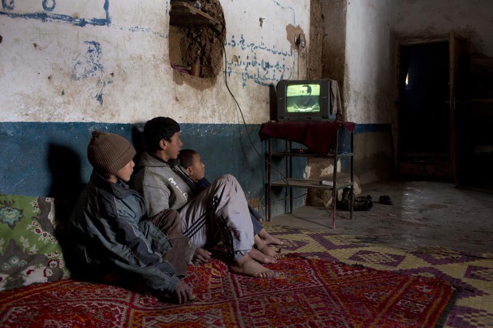 Varios niños miran la tele en su casa en el pueblo de Tilmi.