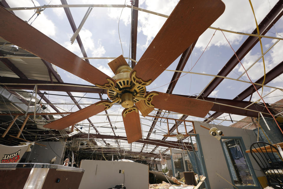 A ceiling fan dangles from a wire in a destroyed bowling alley as residents try to recover from the effects of Hurricane Ida Tuesday, Aug. 31, 2021, in Houma, La. (AP Photo/Steve Helber)