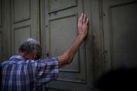 A pensioner leans against the main gate of the national bank of Greece as he waits to withdraw a maximum of 120 euros ($134) for the week in Athens in central Athens, Tuesday, July 7, 2015. Greek Prime Minister Alexis Tsipras heads Tuesday to Brussels, where he will try to use a bailout referendum victory to obtain a rescue deal with European leaders. (AP Photo/Emilio Morenatti)