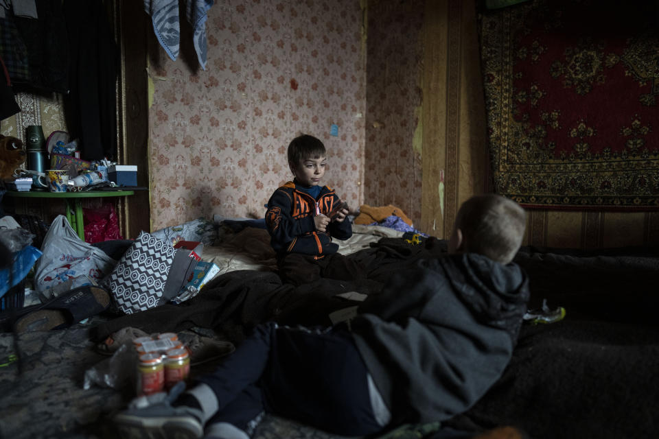 Vlad, 6, plays cards with a friend inside his house in Bucha, in the outskirts of Kyiv, Ukraine, Saturday, April 9, 2022. Vlad's mother died during their confinement in a basement for more than a month during the occupation of the Russian army. (AP Photo/Rodrigo Abd)