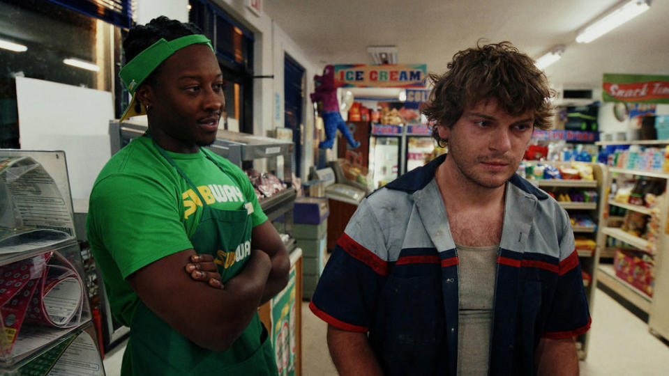 A subway employee observes a shady unkempt young man at a convenience store