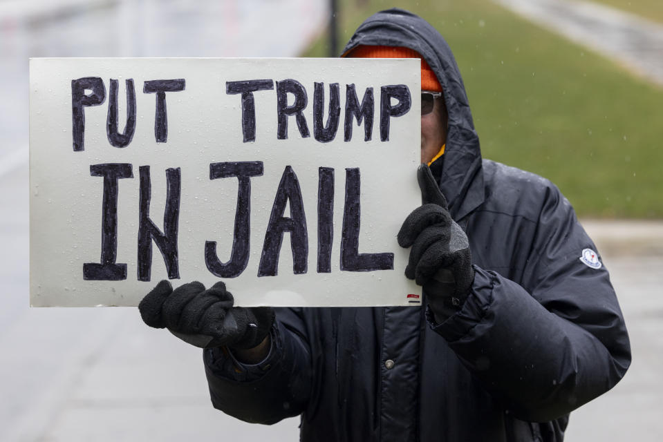 An anti-Trump supporter holds a sign outside Republican presidential candidate former President Donald Trump's rally April 2, 2024, in Green Bay, Wis. (AP Photo/Mike Roemer)