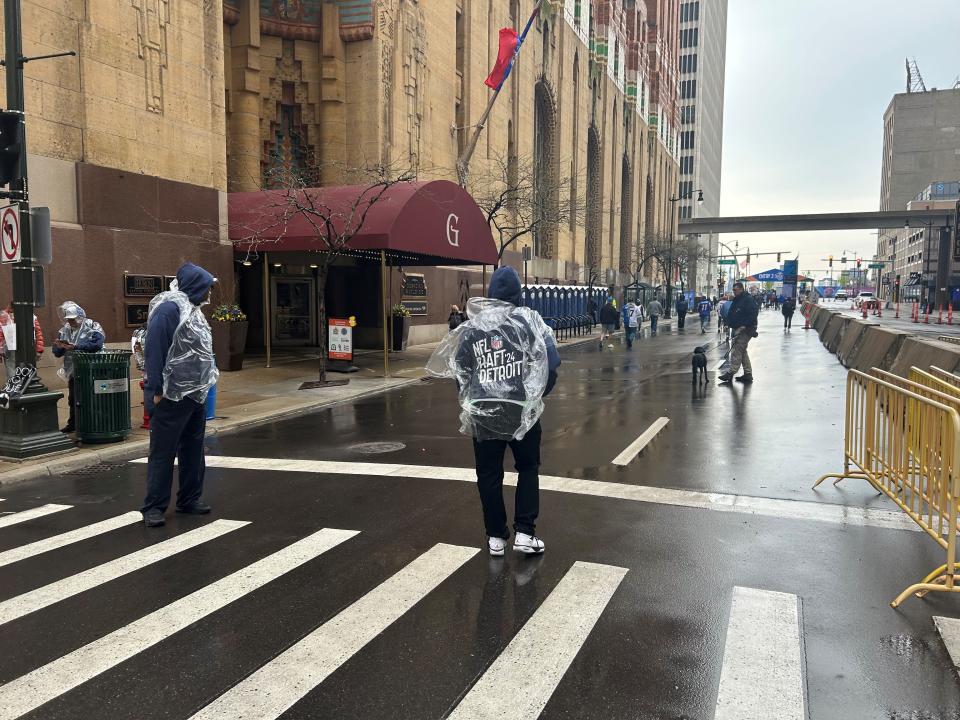 NFL draft staff on Griswold Street wear ponchos during a wet start to the third and final day of the football event in downtown Detroit on April 27, 2024.
