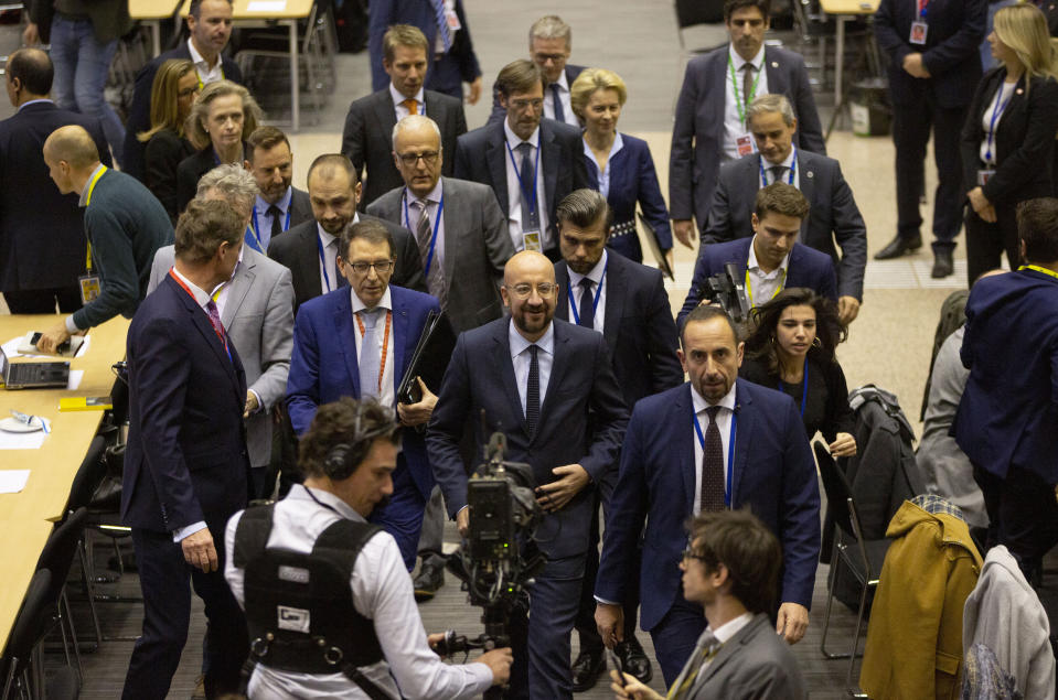 European Council President Charles Michel, center, walks to a media conference during an EU summit in Brussels, Friday, Dec. 13, 2019. European Union leaders gathered for their year-end summit and discussed climate change funding, the departure of the UK from the bloc and their next 7-year budget. (AP Photo/Virginia Mayo)