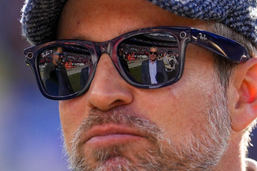 Denver Broncos owner Greg Penner is reflected in the lenses of John Spanos' Ray Ban P Wayfarer Smart glasses before an NFL football game between the Denver Broncos and the Los Angeles Chargers, Sunday, Jan. 8, 2023, in Denver. (AP Photo/Jack Dempsey)