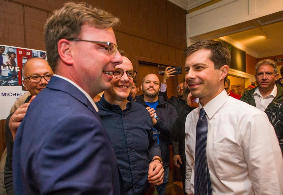 Then-South Bend Mayor Pete Buttigieg and his husband, Chasten, center, congratulate James Mueller at Corby’s Irish Pub on May 7, 2019, after Mueller won the Democratic primary in the city’s mayoral race.