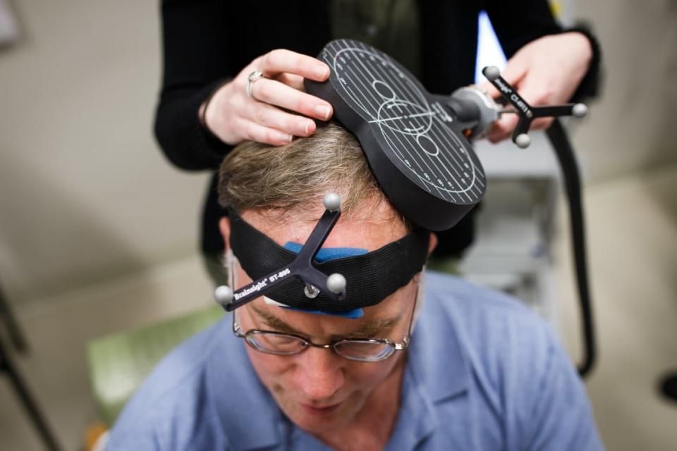 <div class="inline-image__caption"><p>Research assistant Gabrielle Block simulates a TMS therapy session on John Elder Robison at Beth Israel Hospital in Boston.</p></div> <div class="inline-image__credit">Keith Bedford/Boston Globe via Getty</div>