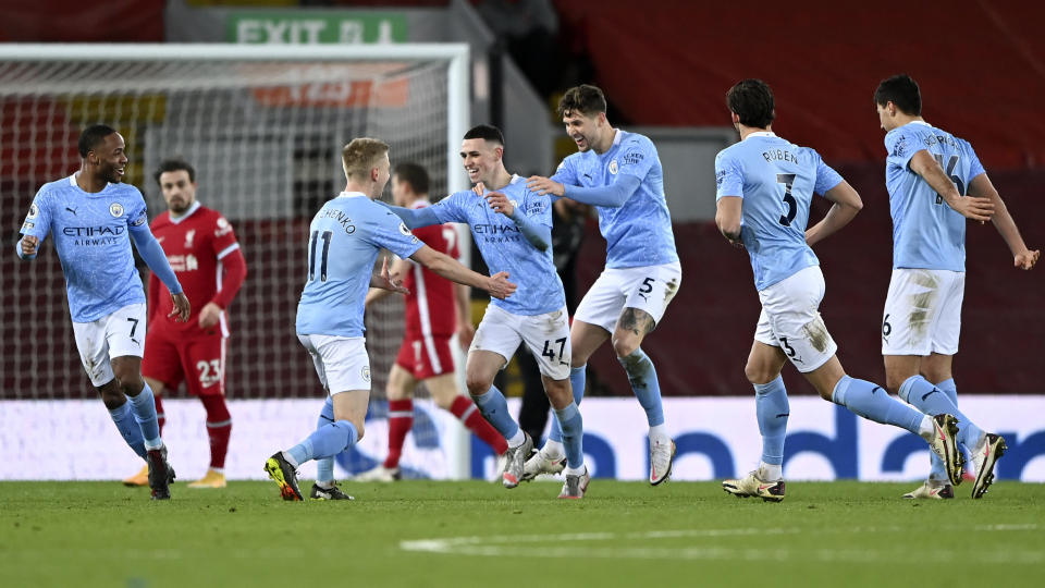 Manchester City's Phil Foden, center, celebrates after scoring his side's fourth goal during the English Premier League soccer match between Liverpool and Manchester City at Anfield Stadium, Liverpool, England, Sunday, Feb. 7, 2021. (Laurence Griffiths/Pool via AP)