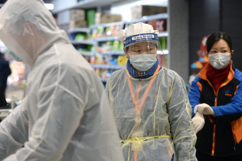 A staff member wearing a protective mask and suit works at a supermarket in Wuhan, the epicentre of the outbreak of a novel coronavirus, in China's central Hubei province. - The death toll from the novel coronavirus surged past 900 in mainland China on February 10, overtaking global fatalities in the 2002-03 SARS epidemic, even as the World Health Organization said the outbreak appeared to be stabilising. (Photo by STR / AFP) / China OUT (Photo by STR/AFP via Getty Images)