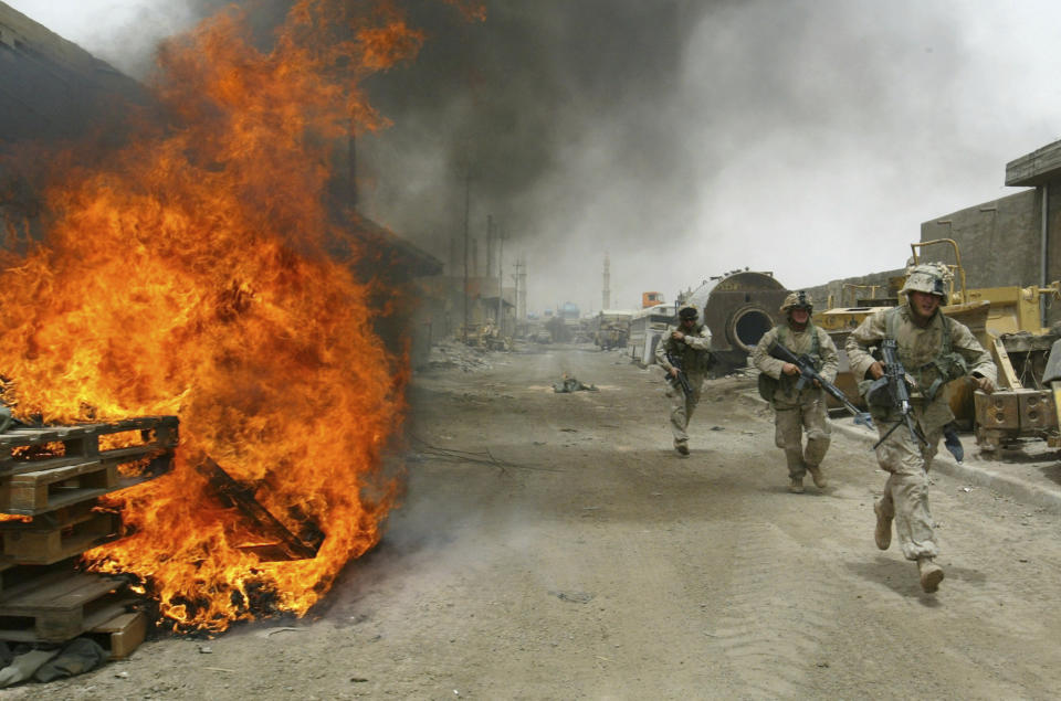 FILE - In this April 30, 2004, file photo, U.S. Marines burn their fortifications on front line positions in Fallujah, Iraq, before pulling out of the city. The U.S. launched its invasion of Iraq on March 20, 2003, unleashing a war that led to an insurgency, sectarian violence and tens of thousands of deaths. (AP Photo/John Moore, File)