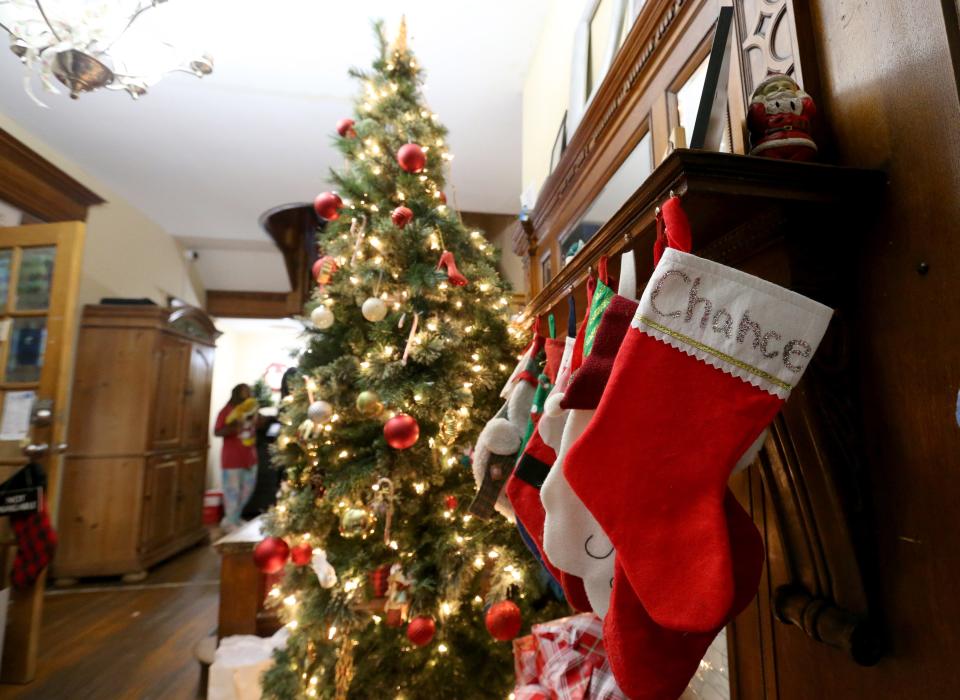 A Christmas tree and stockings hang in the main hall Wednesday, Dec. 20, 2023, at Dismas House in South Bend.