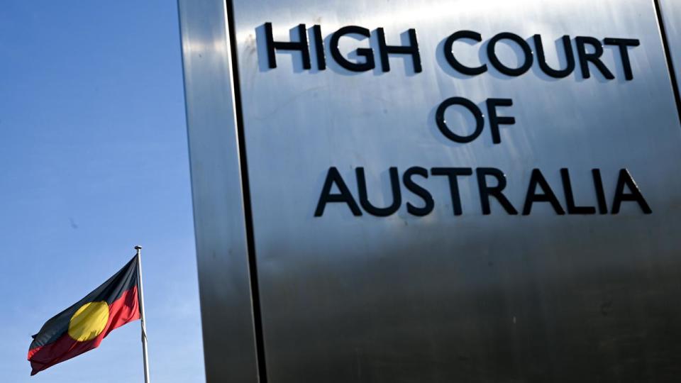 The Indigenous flag flies next to a sign for the High Court.