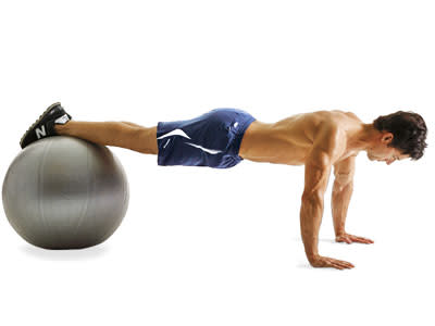 Assume a push-up position with your feet resting on a Swiss ball, your body in a straight line from toes to shoulders.