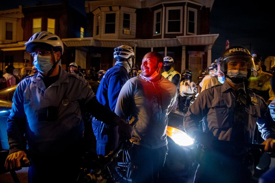 A person is handcuffed and detained by police in Philadelphia, after the citywide curfew had passed (AP)