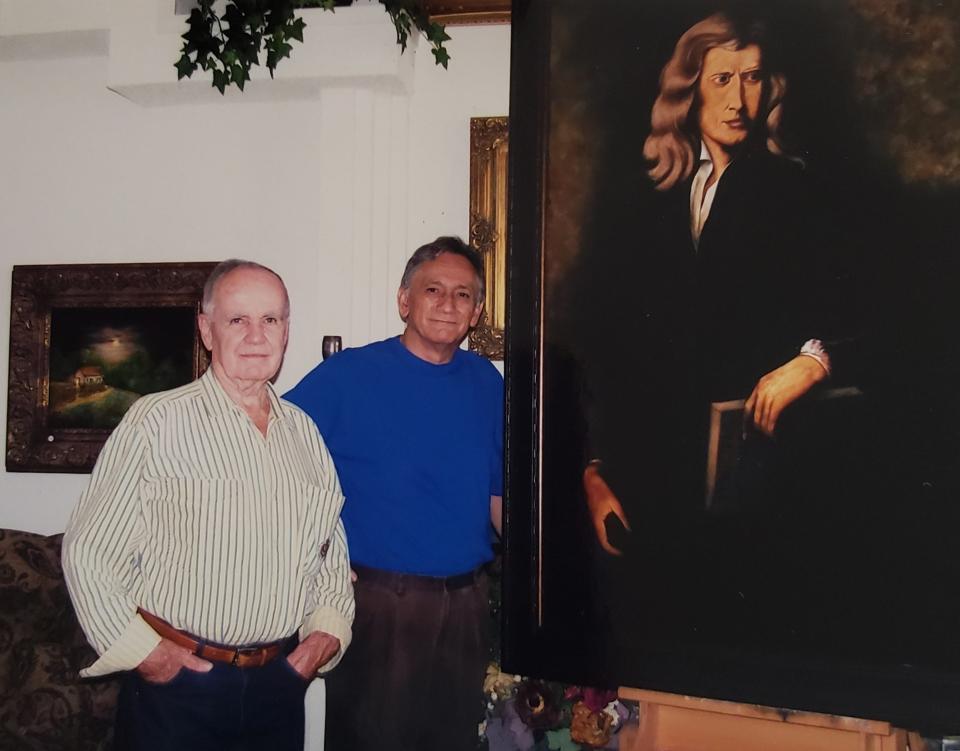 Author Cormac McCarthy stands beside Alberto Escamilla in Escamilla's home. They are by the painting of Sir Isaac Newton that McCarthy commissioned for the Santa Fe Institute in New Mexico.