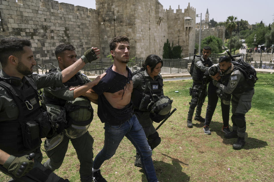 Members of Israeli security forces detain a Palestinian protester near Damascus Gate outside Jerusalem's Old City as Israelis mark Jerusalem Day, an Israeli holiday celebrating the capture of the Old City during the 1967 Mideast war. Sunday, May 29, 2022. Israel claims all of Jerusalem as its capital. But Palestinians, who seek east Jerusalem as the capital of a future state, see the march as a provocation. Last year, the parade helped trigger an 11-day war between Israel and Gaza militants. (AP Photo/Mahmoud Illean)