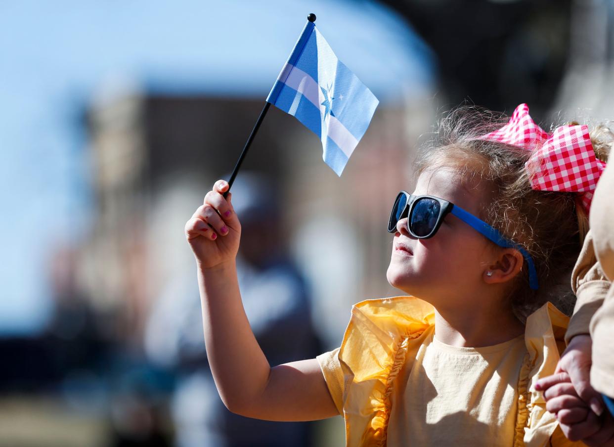 Five-year-old Brinley Sturdfant holds the new flag of Springfield, Mo. as she watches a ceremony on Park Central Square on Tuesday, March 1, 2022.