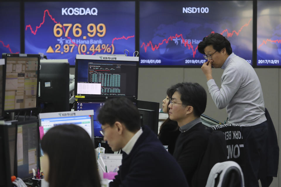 Currency traders watch monitors at the foreign exchange dealing room of the KEB Hana Bank headquarters in Seoul, South Korea, Friday, Jan. 3, 2020. Asian stocks were mixed Friday and oil prices surged after an Iranian general was killed by U.S. forces in Iraq. (AP Photo/Ahn Young-joon)