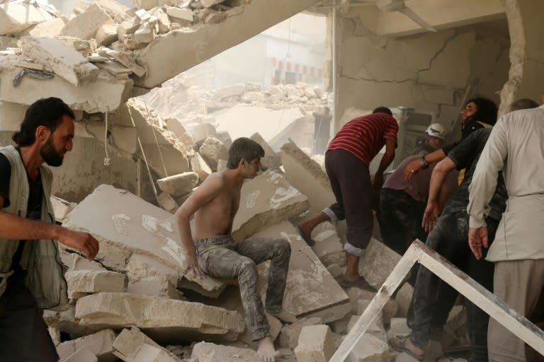 A Syrian man sits in shock in the rubble of a building following a barrel bomb attack on the Bab al-Nairab neighbourhood of the northern Syrian city of Aleppo on August 25, 2016