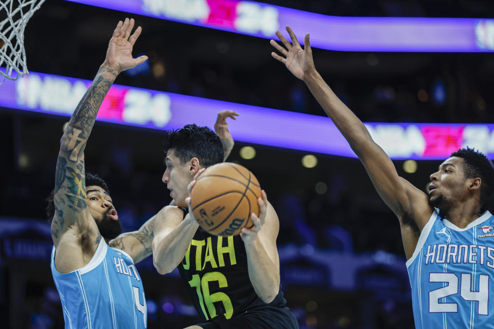 Utah Jazz forward Simone Fontecchio, center, drives between Charlotte Hornets center Nick Richards (4) and forward Brandon Miller (24) during the first half of an NBA basketball game in Charlotte, N.C., Saturday, Jan. 27, 2024. (AP Photo/Nell Redmond)