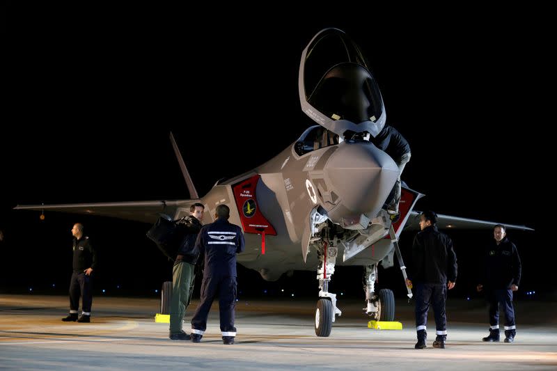 FILE PHOTO: Israeli soldiers walk near a F-35 fighter jet after it landed in Israel at Nevatim air base after the Israeli air force bought them at Nevatim