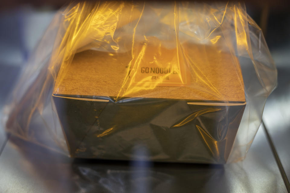 A ready to take away Go Noodles box is placed in a glass-paned locker in Tel Aviv, Israel, Thursday, July 16, 2020. The coronavirus crisis and its economic impact have forced many small businesses and restaurants to shut their doors in recent months, but Tel Aviv's Go Noodles opened a new branch last week that features digital-only ordering and pickup from lockers. (AP Photo/Ariel Schalit)