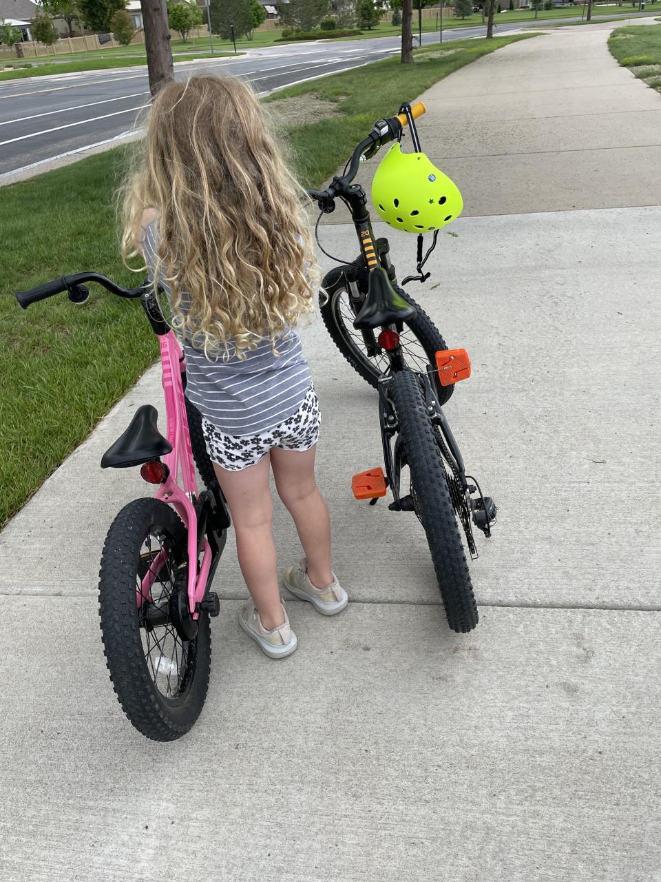 The author's daughter standing next to bikes