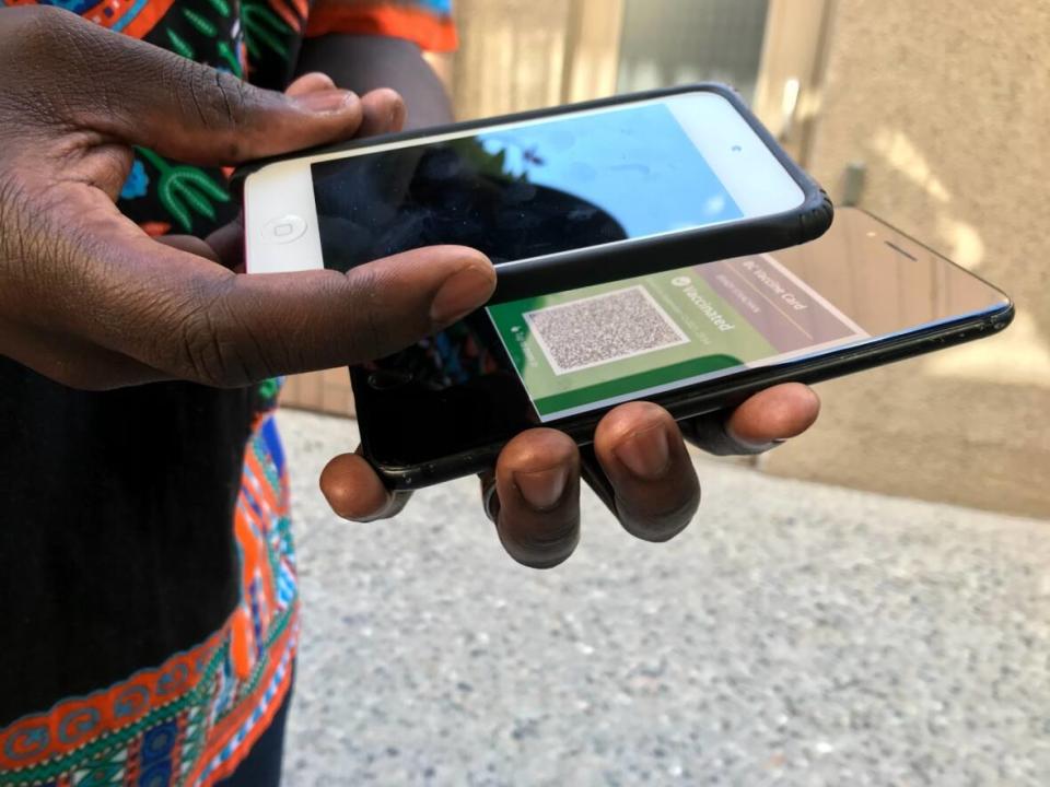 A man scans a customer’s vaccine card in Kelowna, B.C. The province’s vaccine passport goes into effect on Monday.   (Brady Strachan/CBC - image credit)