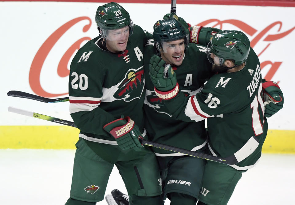 FILE - Minnesota Wild's Ryan Suter (20) and Jason Zucker (16) congratulate left wing Zach Parise (11) on his goal against the Arizona Coyotes during the third period of an NHL hockey game in St. Paul, Minn., in this Thursday, Nov. 14, 2019, file photo. After signing with Minnesota together, Zach Parise and Ryan Suter are being bought out together. The Wild announced Tuesday, July 13, 2021, that the team is buying out the final four years of each player's contract, a stunning move early in the NHL offseason. (AP Photo/Hannah Foslien, File)