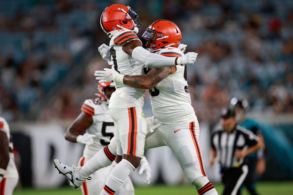 Cleveland Browns safety D'Anthony Bell, left, is hugged by defensive end Curtis Weaver after Bell forced a fumble during the third quarter of a preseason game Friday, Aug. 12, 2022 in Jacksonville.