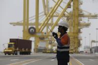 A port employee works at Hamad Port, about 25 kms south of Doha, Qatar on May 6, 2019. Qatar is home to roughly 2.6 million people, but a tiny fraction of that — around 12% — are Qatari citizens. They enjoy massive wealth and benefits fueled by Qatar's shared control of one of the world's largest reserves of natural gas. (AP Photo/Kamran Jebreili)