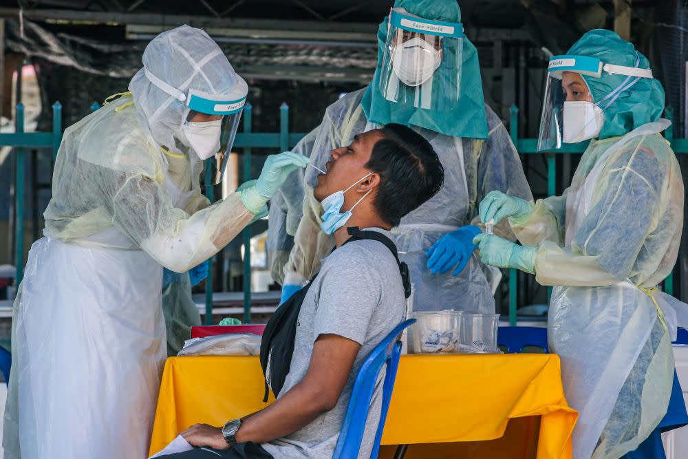 A man undergoes a swab test during a Covid-19 screening exercise in Taman Langat Utama June 3, 2020. — Picture by Hari Anggara