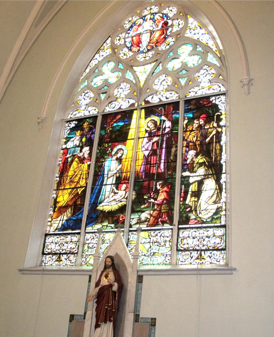 In this Jan. 12, 2014 photo, a stained glass window inside 114-year-old Our Lady of Perpetual Help Church in Buffalo, N.Y., is shown during a “Mass Mob.” Borrowed from the idea of flash mobs, Mass Mobs encourages crowds to attend Mass at a specified church on a certain day to fill pews, lift spirits and help financially some of the city’s most historic but often sparsely attended churches. (AP Photo/Carolyn Thompson)