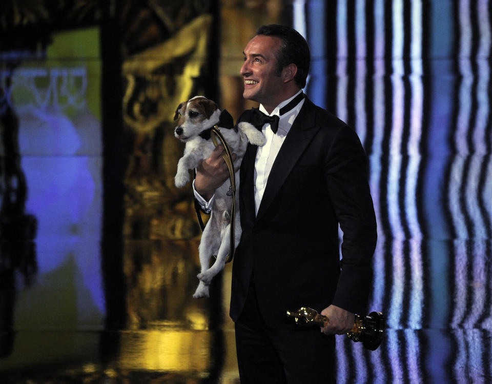 Jean Dujardin holds Uggie after accepting the Oscar for best picture for “The Artist” during the 84th Academy Awards on Sunday, Feb. 26, 2012, in the Hollywood section of Los Angeles. (AP Photo/Mark J. Terrill)