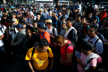 People pray before departing with a caravan of migrants from El Salvador en route to the United States, in San Salvador, El Salvador, October 28, 2018. REUTERS/ Jose Cabezas