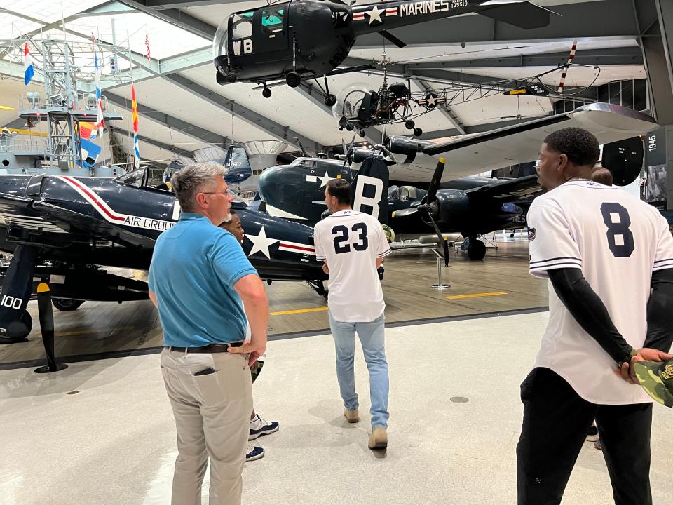 Jason Bortz, public affairs officer at NAS Pensacola, shows various replica planes to Blue Wahoos players Colton Hock (23) Thomas Jones (8) and Cobie Fletcher-Vance during a recent tour of the National Naval Aviation Museum at NAS-Pensacola.