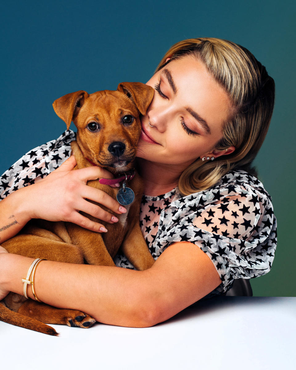 Flo hugging a puppy that looks into the camera