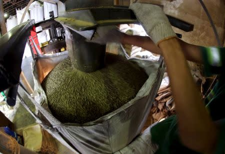 FILE PHOTO: A worker fills a 1-tonne super sack with coffee beans for export at a coffee warehouse in Santos, Brazil, on December 10, 2015. REUTERS/Paulo Whitaker/File Photo