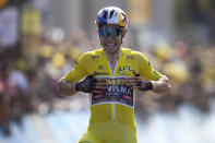 Belgium's Wout Van Aert, wearing the overall leader's yellow jersey celebrates as he crosses the finish line to win the fourth stage of the Tour de France cycling race over 171.5 kilometers (106.6 miles) with start in Dunkerque and finish in Calais, France, Tuesday, July 5, 2022. (AP Photo/Thibault Camus)
