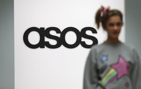 FILE PHOTO: A model walks on an in-house catwalk at the ASOS headquarters in London April 1, 2014. REUTERS/Suzanne Plunkett