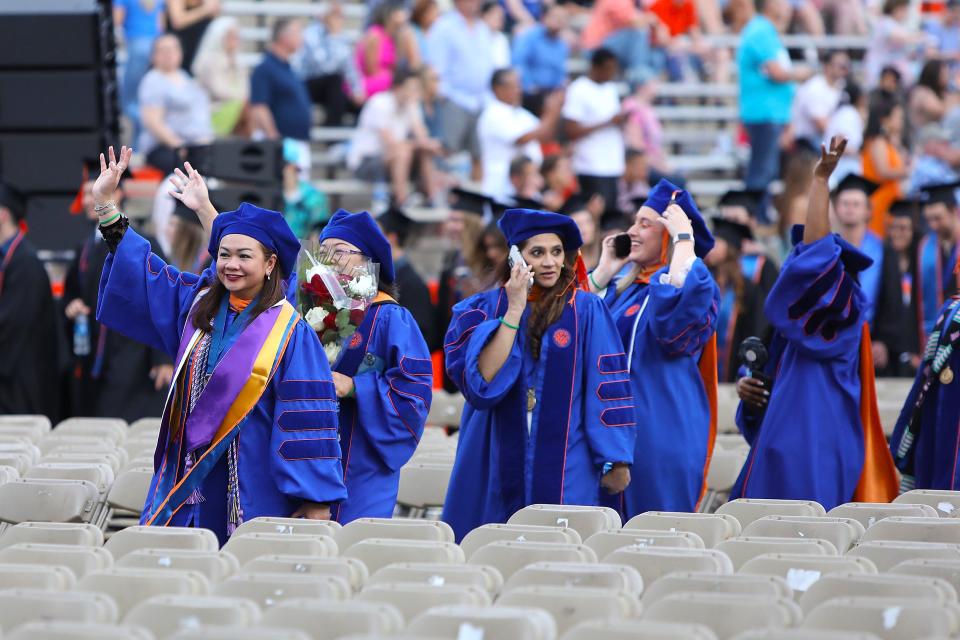 University of Florida graduate students in nursing wave as they make their way into the Spring 2022 Commencement Ceremony being held at Ben Hill Griffin Stadium, in Gainesville Fla. April 29, 2022. Florida Gators great Tim Tebow was the commencement speaker. He talked about not just being successful, but being sure that you were being significant.