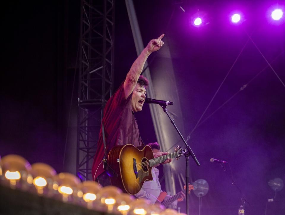 Marty Raybon points with one hand as he sings into a microphone onstage