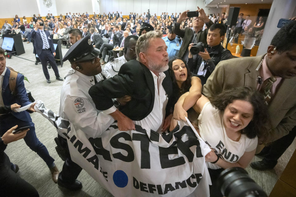 Climate protestors are removed after interrupting a speech by Federal Reserve Chairman Jerome Powell at the 24th Jacques Polak Research Conference at the International Monetary Fund on Thursday, Nov. 9, 2023 in Washington. (AP Photo/Mark Schiefelbein)