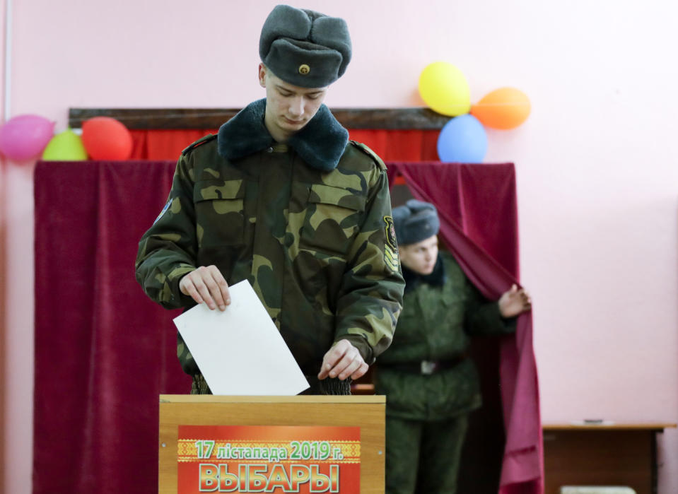 In this photo taken on Thursday, Nov. 14, 2019, a Belarus Army serviceman casts his ballot during an early election at a polling station in Minsk, Belarus, ahead of the parliamentary election to be held on Sunday. (AP Photo/Sergei Grits)